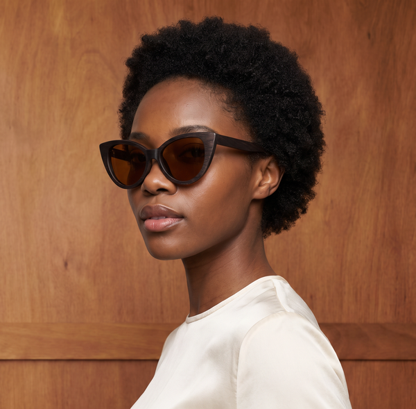 Model is wearing the Selina Brown Bamboo sunglasses with Tea colored polarized UV400 lenses.  Her face is angled to the camera. 
